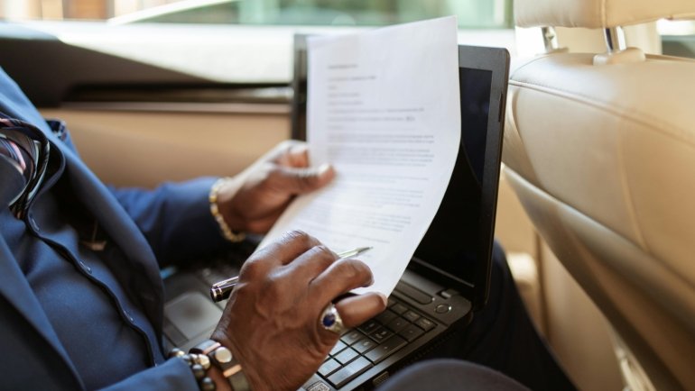 Professional travel agent explaining a custom vacation itinerary to clients, illustrating how agencies are paid through commissions and service fees for expert travel planning and booking services.