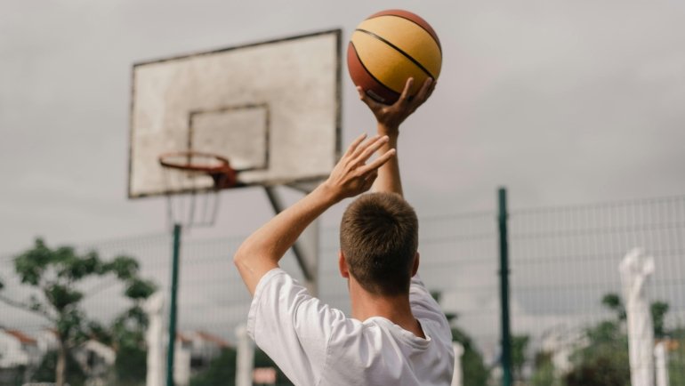 Basketball player executing a legal pivot move on the court, showcasing correct footwork and body control to avoid travel violations and master essential basketball rules.
