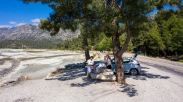 Tesla holiday travel charging solution at a scenic EV charging station, ensuring a stress-free electric car road trip for families.