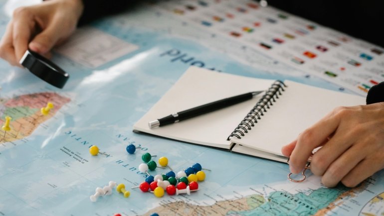 Hands replacing a vibrant elastic band on a leather Midori Traveler's Notebook, illustrating the easy repair and personalization process for a unique travel journal.