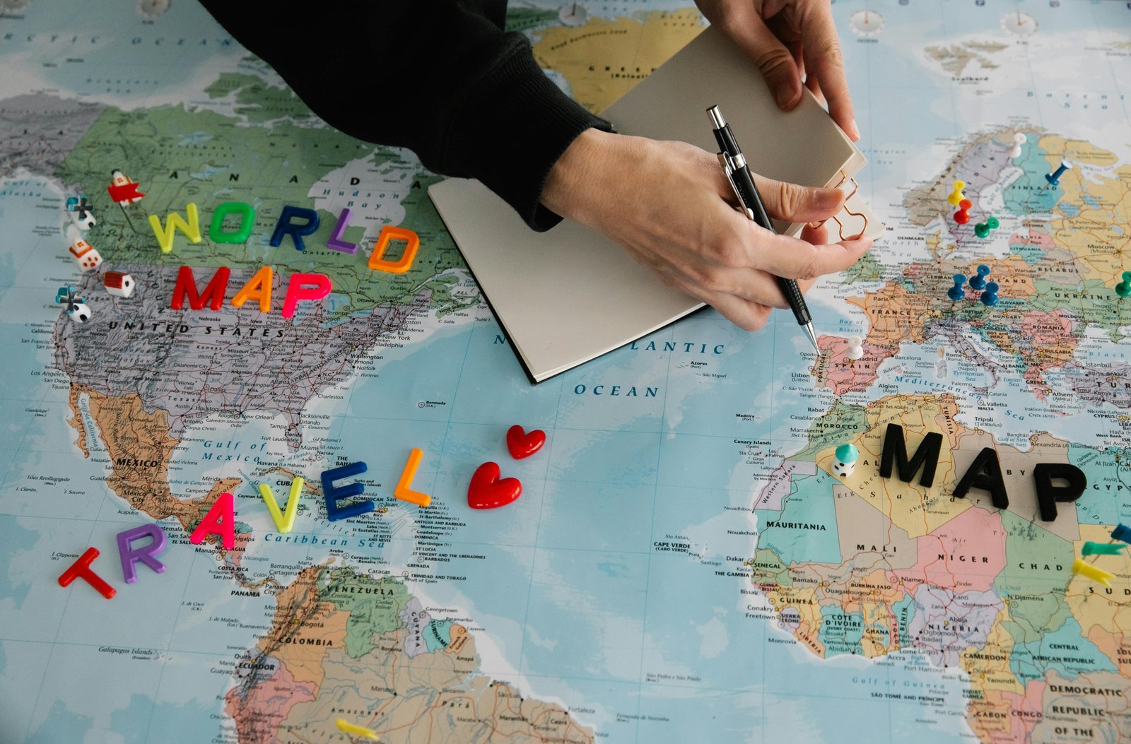 Travel bucket list planning desk with a world map, journal, and various travel inspirations, representing future adventures, cultural experiences, and relaxing trips.