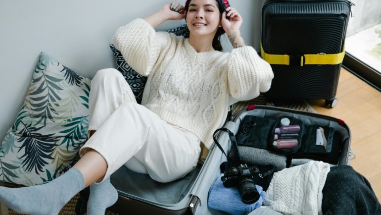 A person efficiently packing lightweight, high-performance travel shirts, including merino wool and synthetic options, into a suitcase for a comfortable and wrinkle-free adventure.