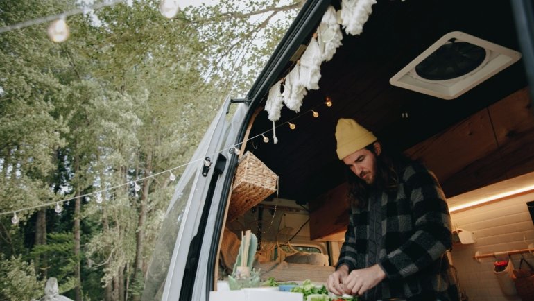 Portable slow cooker cooking a healthy and delicious meal during a road trip, perfect for camping and travel adventures, emphasizing convenience and savings.