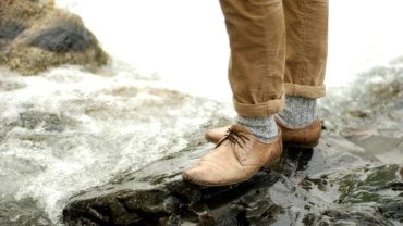 A traveler confidently walking through a city street wearing comfortable and versatile Kirkland Signature travel pants, showcasing their durable, quick-drying, and affordable design perfect for various trips.