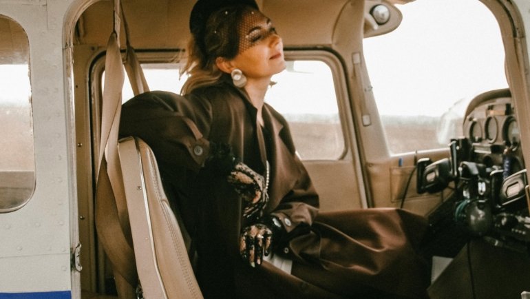 A traveler comfortably resting with a supportive travel pillow on an airplane seat, illustrating essential neck support and relaxation for long journeys.