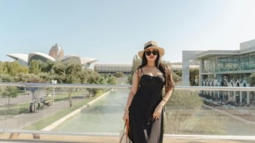 Happy plus size woman in a stylish and comfortable travel dress, confidently exploring a beautiful international destination, showcasing versatile fashion for adventures.