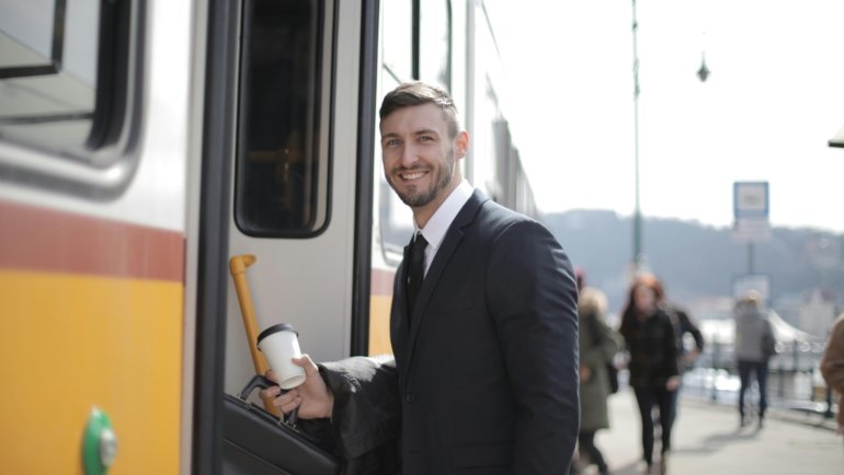 Person commuting with a vibrant Dunkin Donuts travel mug, enjoying their hot coffee and showcasing brand loyalty.