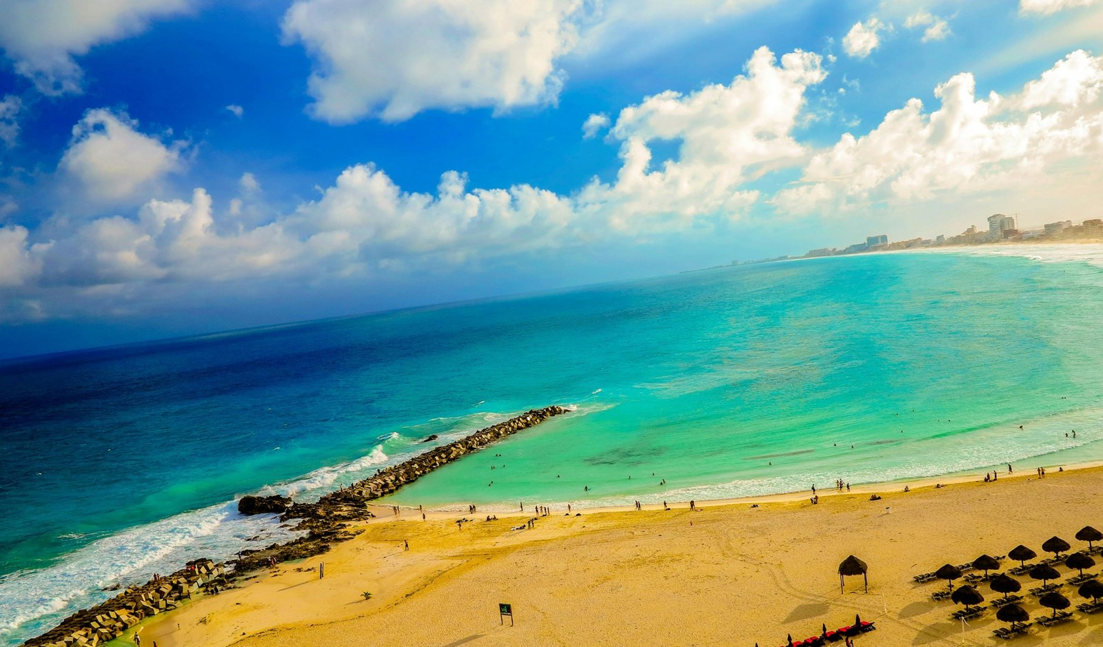 Best months to travel to Cancun: A pristine beach with turquoise water, white sand, and palm trees under clear skies, perfect for planning your ideal Mexican vacation.