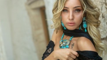 Best summer travel scarf for women: stylish woman wearing a versatile, lightweight scarf for sun protection and chic outfits on her trip.