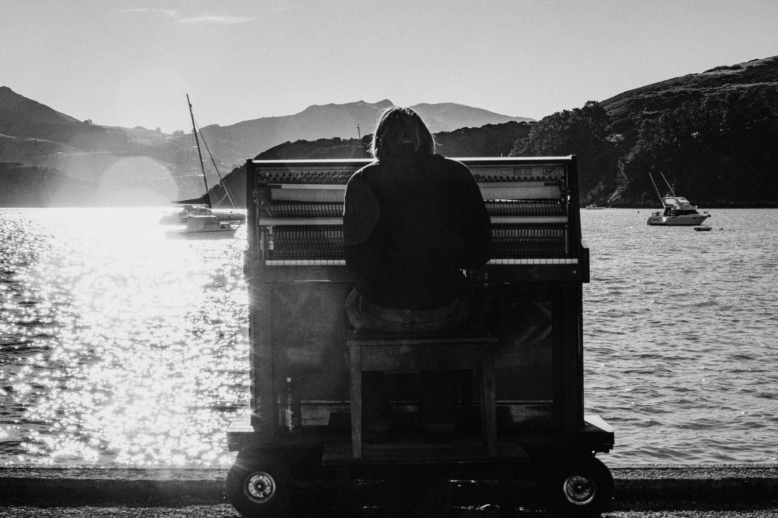 A musician playing a lightweight portable travel piano in a scenic outdoor setting, demonstrating how easily musicians can practice and compose music on the go during their adventures.