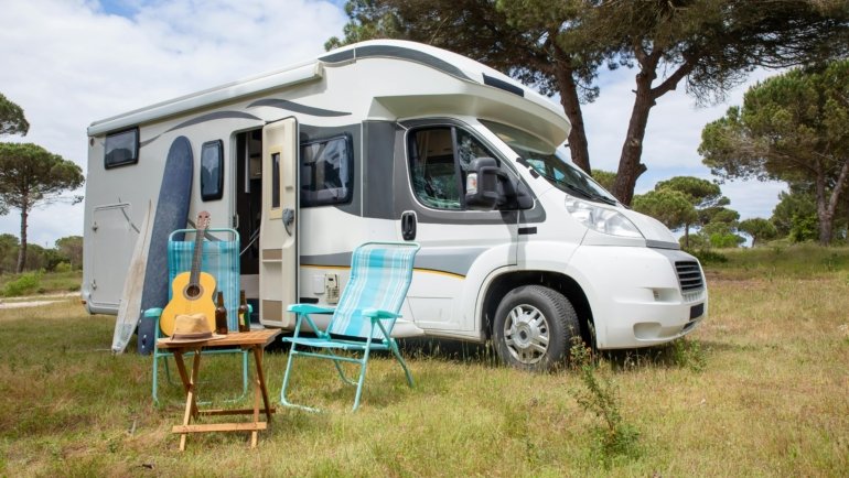 Modern Catalina travel trailer in a picturesque mountain campsite, perfect for an adventurous RV road trip and comfortable camping.