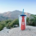 Personalized travel coffee mug with a custom design or photo being held in an inspiring outdoor setting, perfect for adventurers and unique on-the-go coffee experiences.