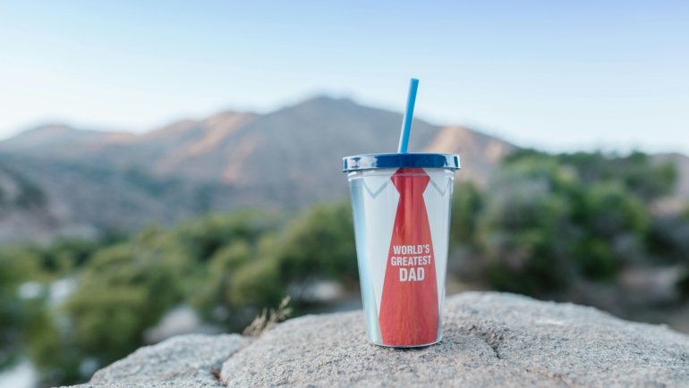 Personalized travel coffee mug with a custom design or photo being held in an inspiring outdoor setting, perfect for adventurers and unique on-the-go coffee experiences.
