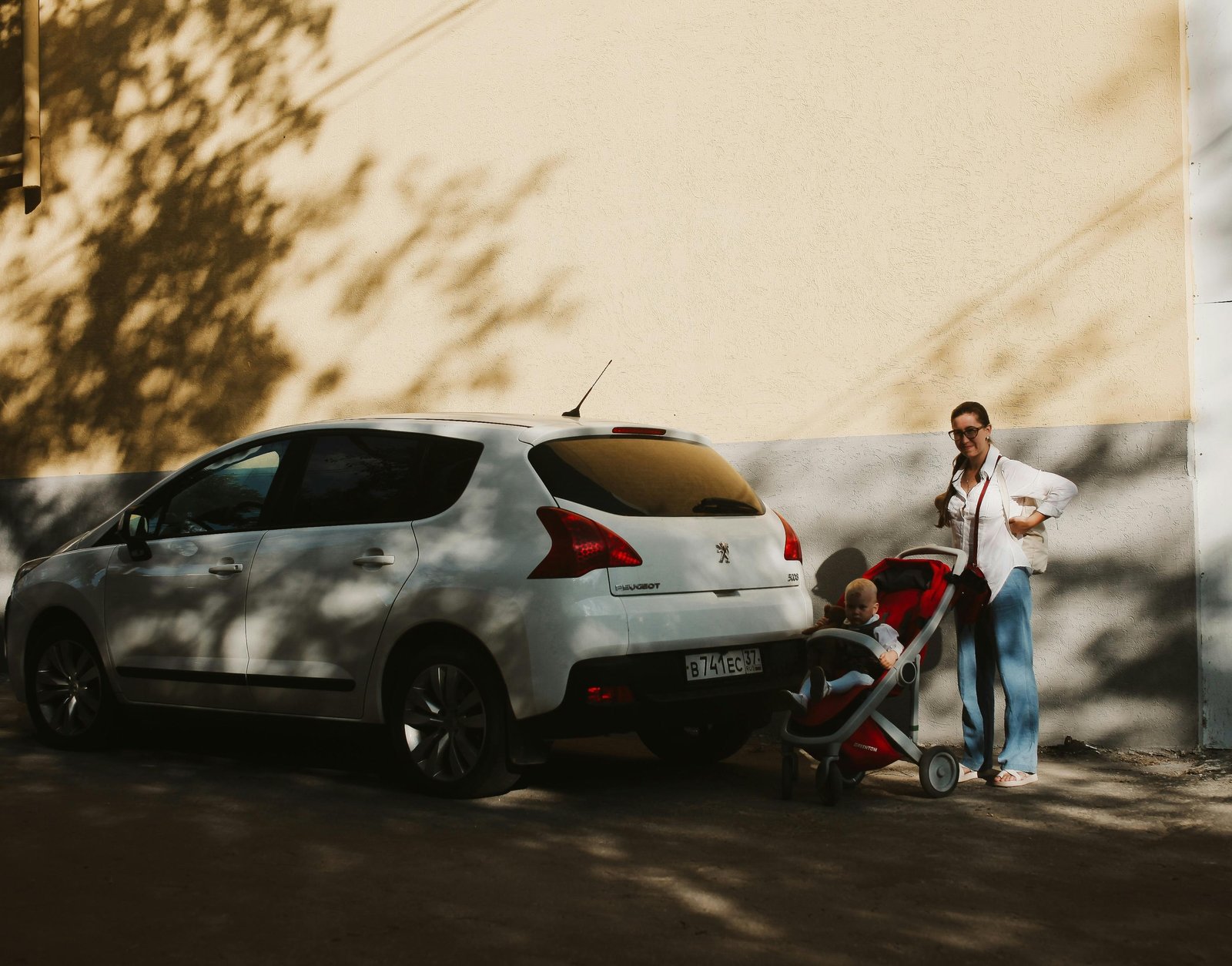 Happy parents pushing a lightweight Chicco travel stroller with their baby through a busy airport terminal, highlighting convenient family travel.