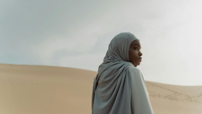 A female pearl rhythm traveler enjoying a moment of mindful reflection in a serene natural environment, symbolizing slow, sustainable, and culturally appreciative travel.
