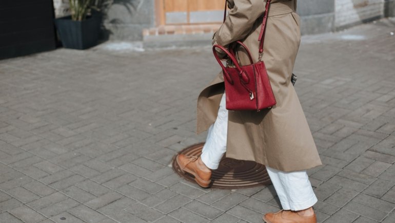 Stylish woman carrying secure travel handbag walking in European city street