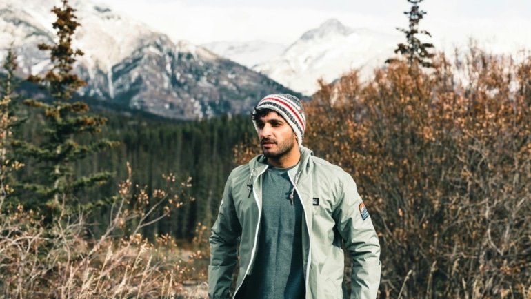 Traveler wearing a weather-resistant travel jacket outdoors in a versatile environment