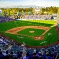 Excited baseball fans cheering in a packed stadium during a sunny day baseball travel trip