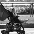 Parent traveling with lightweight stroller in city showing portable and compact baby stroller for easy travel