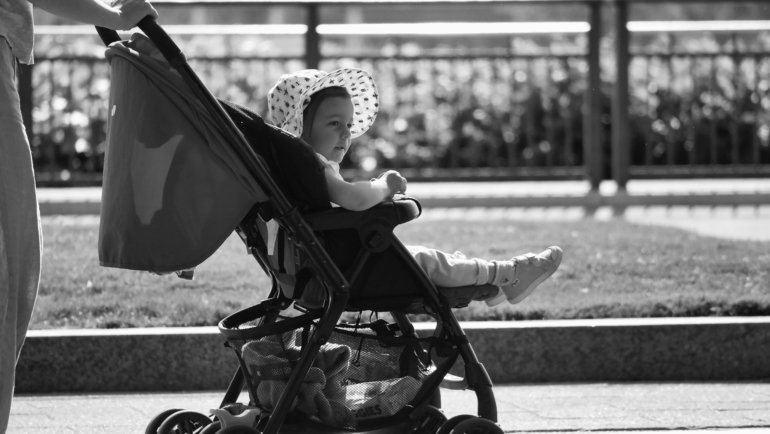 Parent traveling with lightweight stroller in city showing portable and compact baby stroller for easy travel