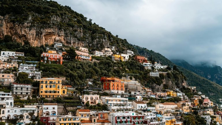 Scenic view of colorful Amalfi Coast villages perched on cliffs above the clear blue Mediterranean Sea
