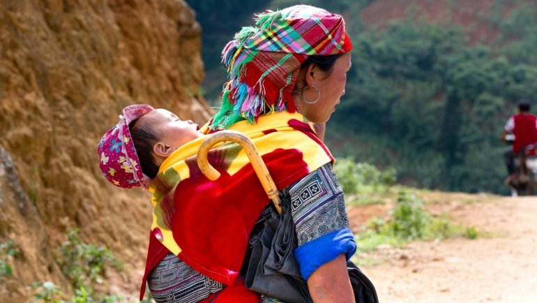Parent with organized baby travel bag ready for family trip with newborn essentials