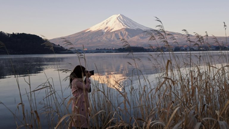 Traveler using a compact camera to capture stunning outdoor scenery during travel
