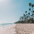 Sunny tropical beach in Punta Cana with clear turquoise water and visitors enjoying a peaceful Caribbean vacation