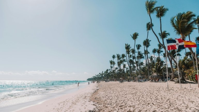 Sunny tropical beach in Punta Cana with clear turquoise water and visitors enjoying a peaceful Caribbean vacation