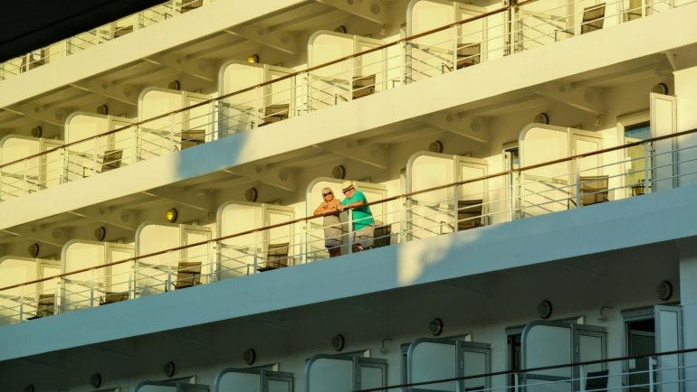 Happy couple enjoying their cruise vacation onboard, representing the ease of booking with expert cruise travel agents