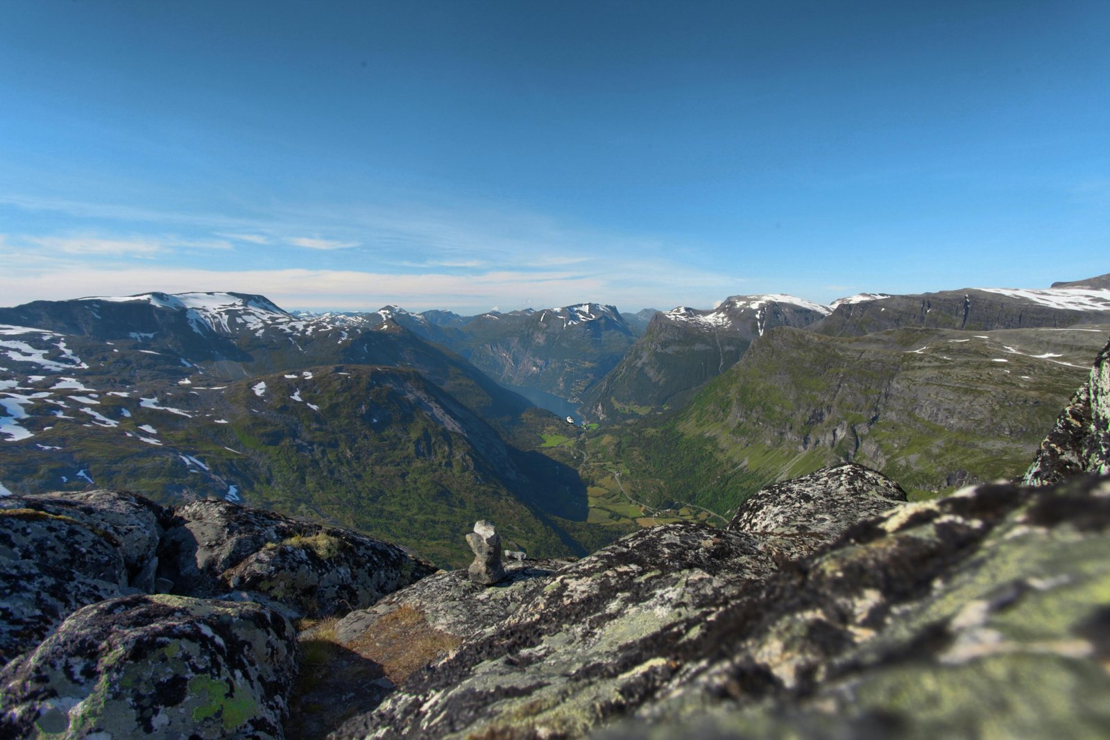 Scenic Norwegian fjords in summer with green hills, calm water, and bright daylight