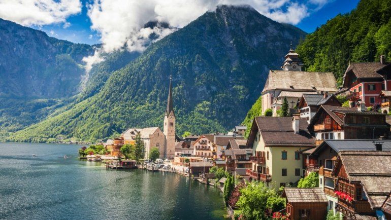 Scenic Austrian landscape illustrating spring blooms, summer greenery, autumn colors, and winter snow showcasing best times to travel to Austria