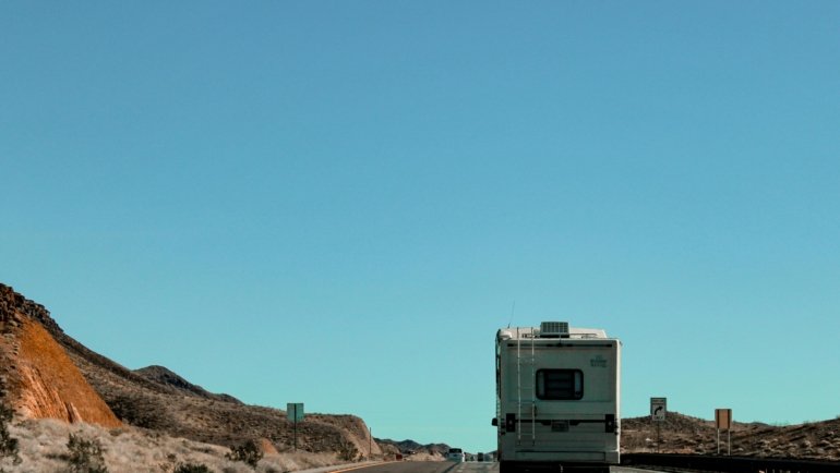 Lightweight 3000 lb travel trailer towed by SUV on scenic road trip with nature background