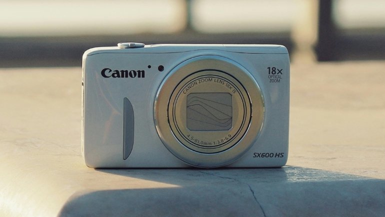 Traveler using a compact digital camera outdoors to capture high-quality travel photos