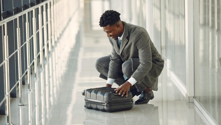 Business traveler wearing a wrinkle-resistant travel suit walking confidently through an airport terminal