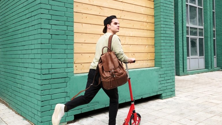 Traveler with a small backpack walking through a busy urban street symbolizing light and flexible travel