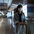 Woman holding a stylish and secure travel wallet at the airport, illustrating organized and stress-free travel for women