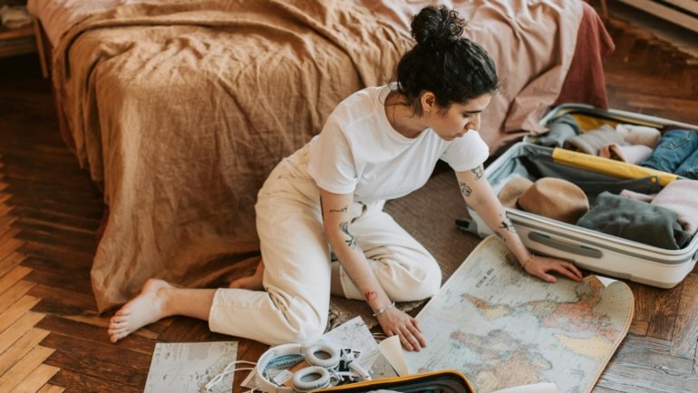 Traveler with luggage and world map ready for adventure and exploration