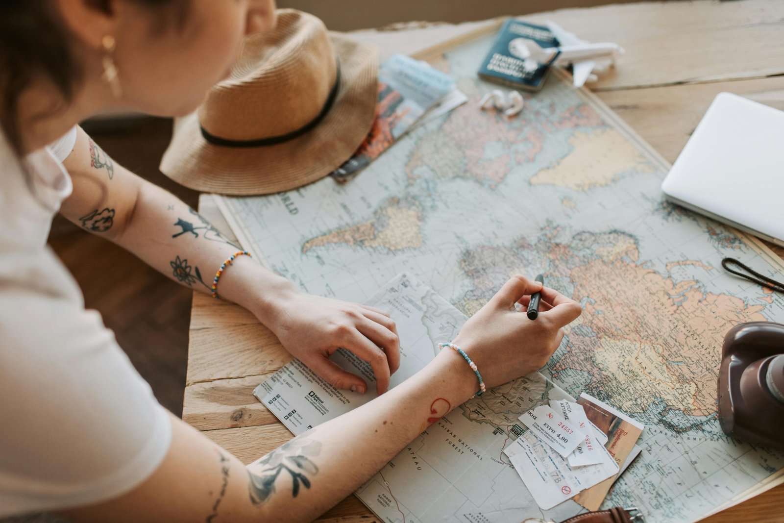 Travel agent preparing a detailed itinerary with maps and documents for clients