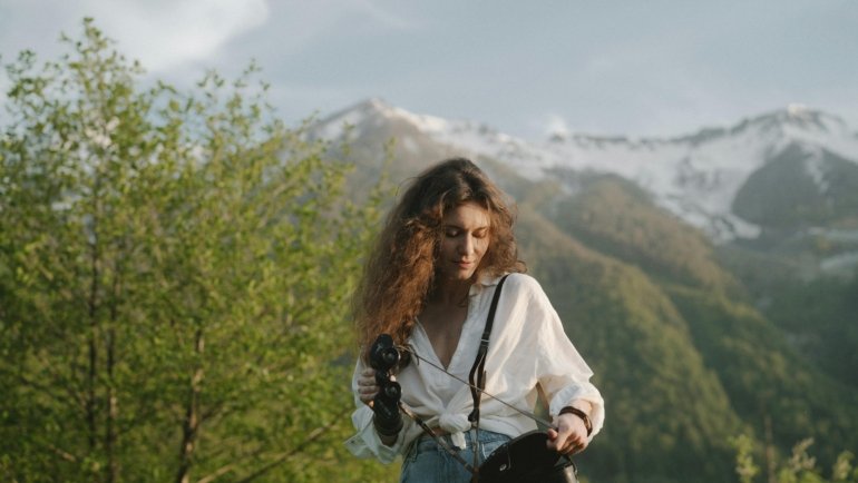 Traveler using compact travel binoculars in nature for sightseeing and birdwatching