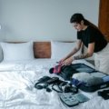 Woman traveler organizing suitcase with packing cubes and travel accessories for a trip