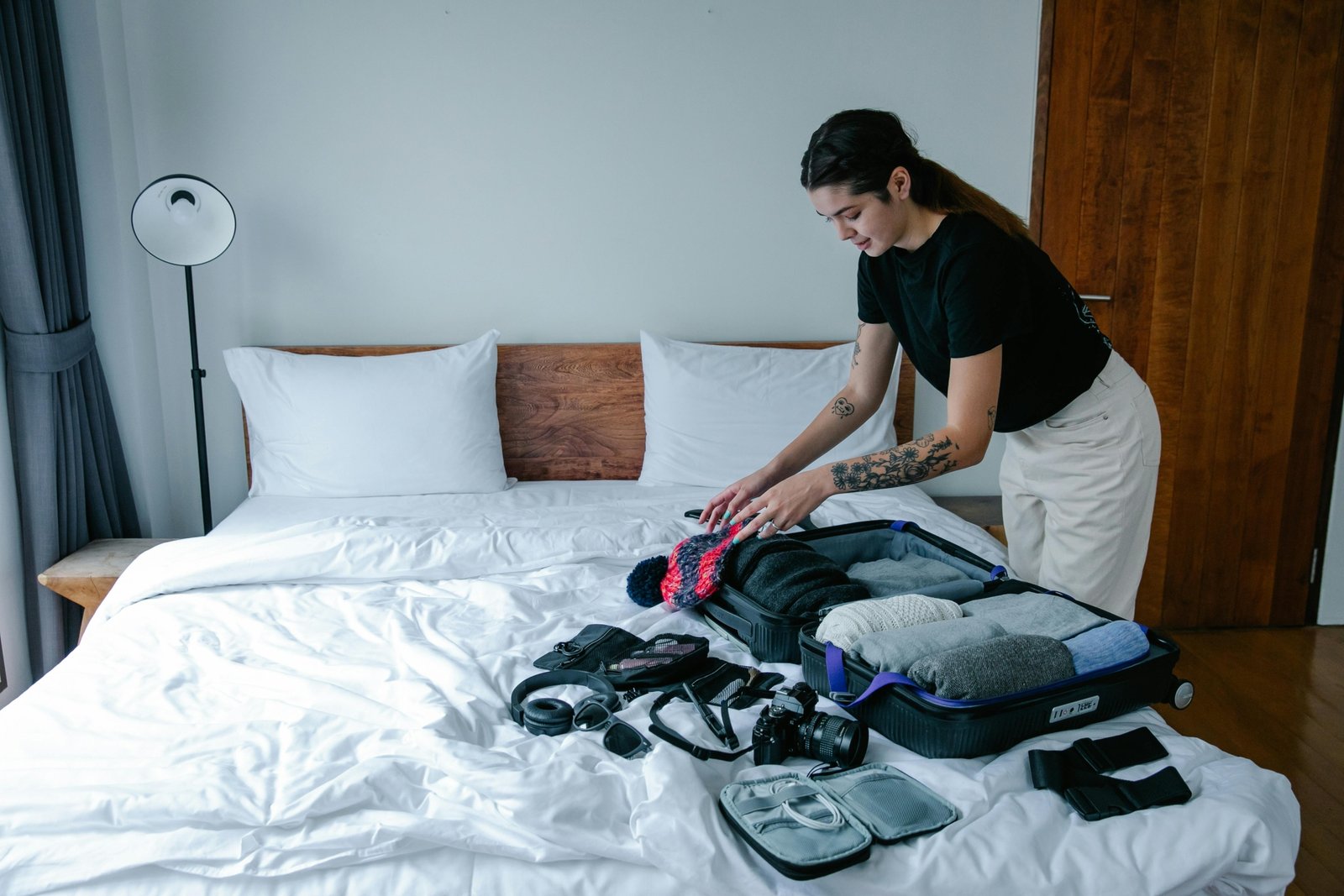 Woman traveler organizing suitcase with packing cubes and travel accessories for a trip