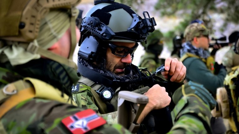 Military personnel reviewing travel documents and security briefings prior to overseas deployment