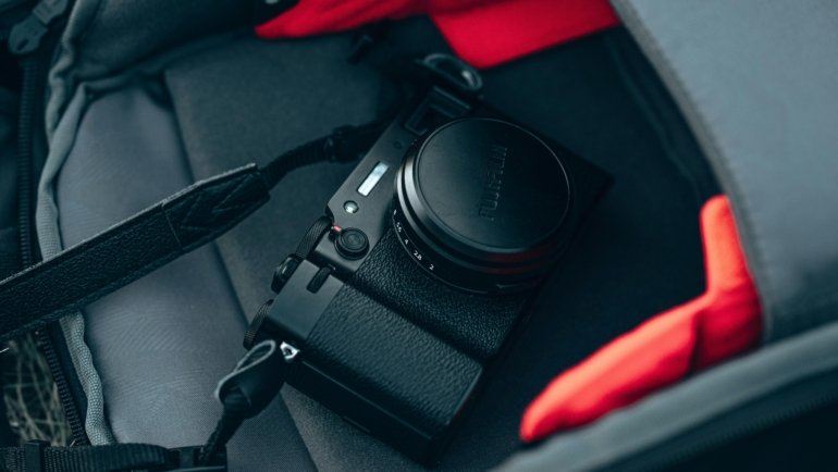 Compact travel camera in a backpack ready for adventure and photography on the go
