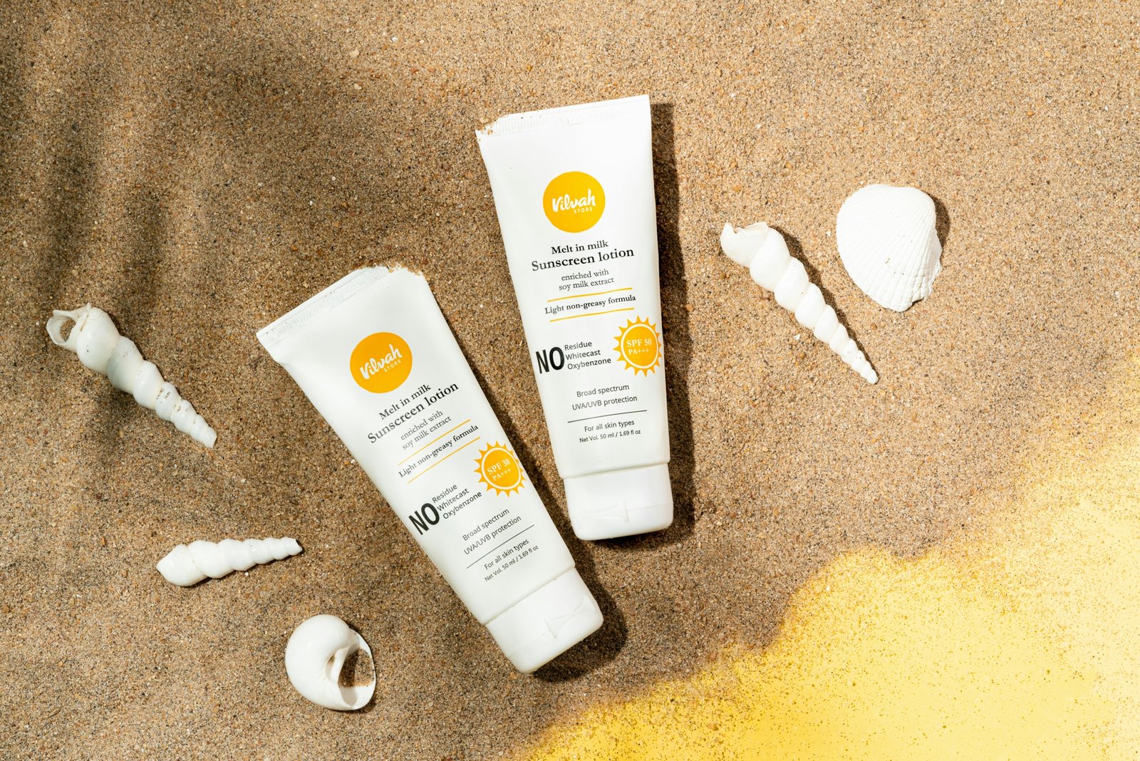 Sun Bum travel size sunscreen and lip balm with travel essentials on a sunny beach for convenient and eco-friendly sun protection