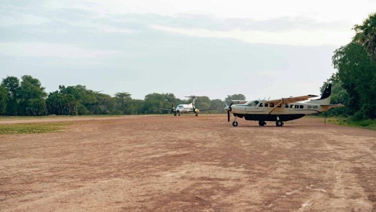 Small charter plane landing on a remote forest airstrip near gorilla trekking park in East Africa