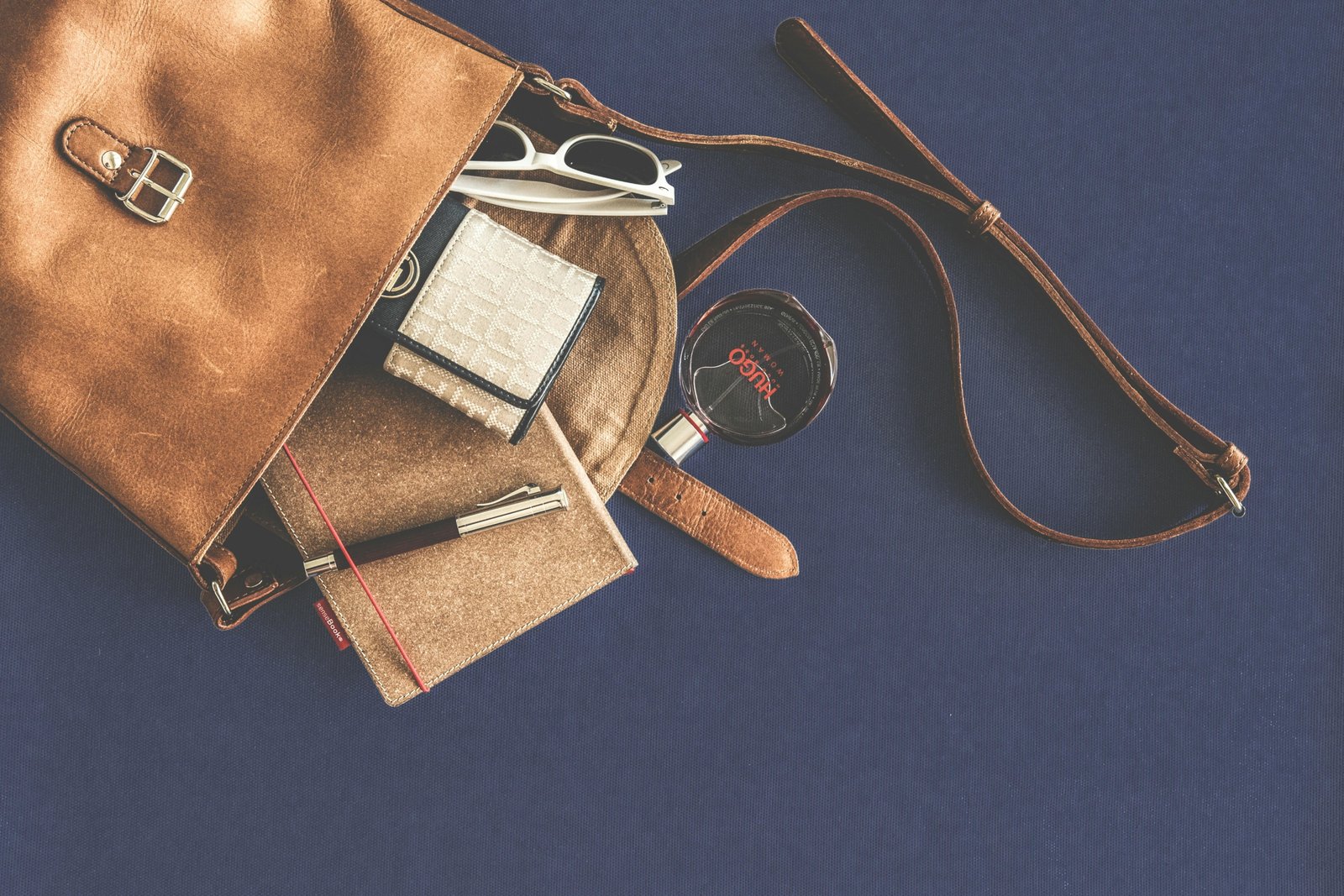 Luxury travel accessories including designer luggage, leather passport holders, noise-canceling headphones, and skincare kit for sophisticated travelers