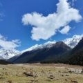 Panoramic view of Sikkim hills with snow-capped mountains and lush greenery, showcasing nature and travel in Northeast India