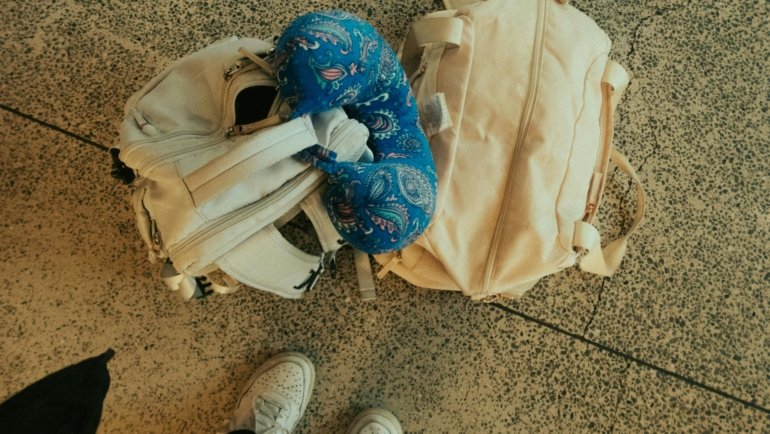 Traveler resting comfortably with an ergonomic travel pillow on an airplane seat