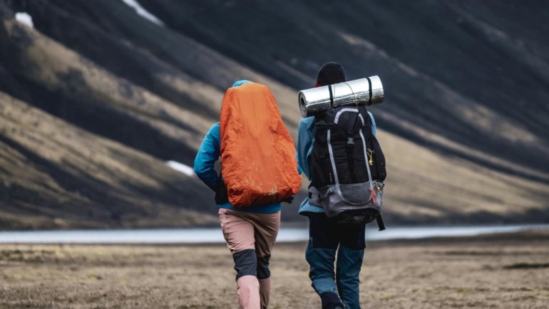 Traveler wearing lightweight quick-dry travel pants hiking outdoors with scenic background